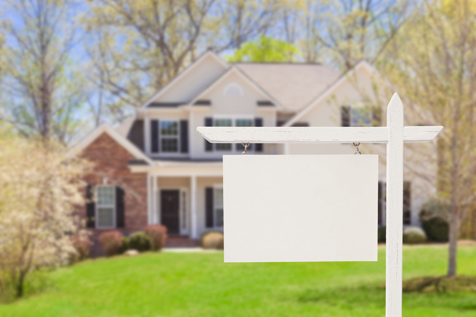 Blank Real Estate Sign in Front of Beautiful New House.