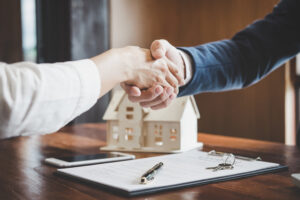 Real estate agent and customers shaking hands together celebrati